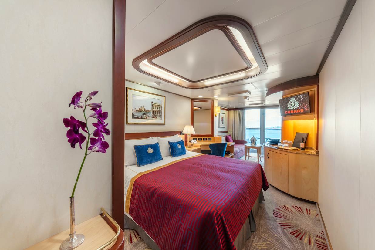 View of the bed and balcony of a Princess Grills suite on a Cunard cruise ship
